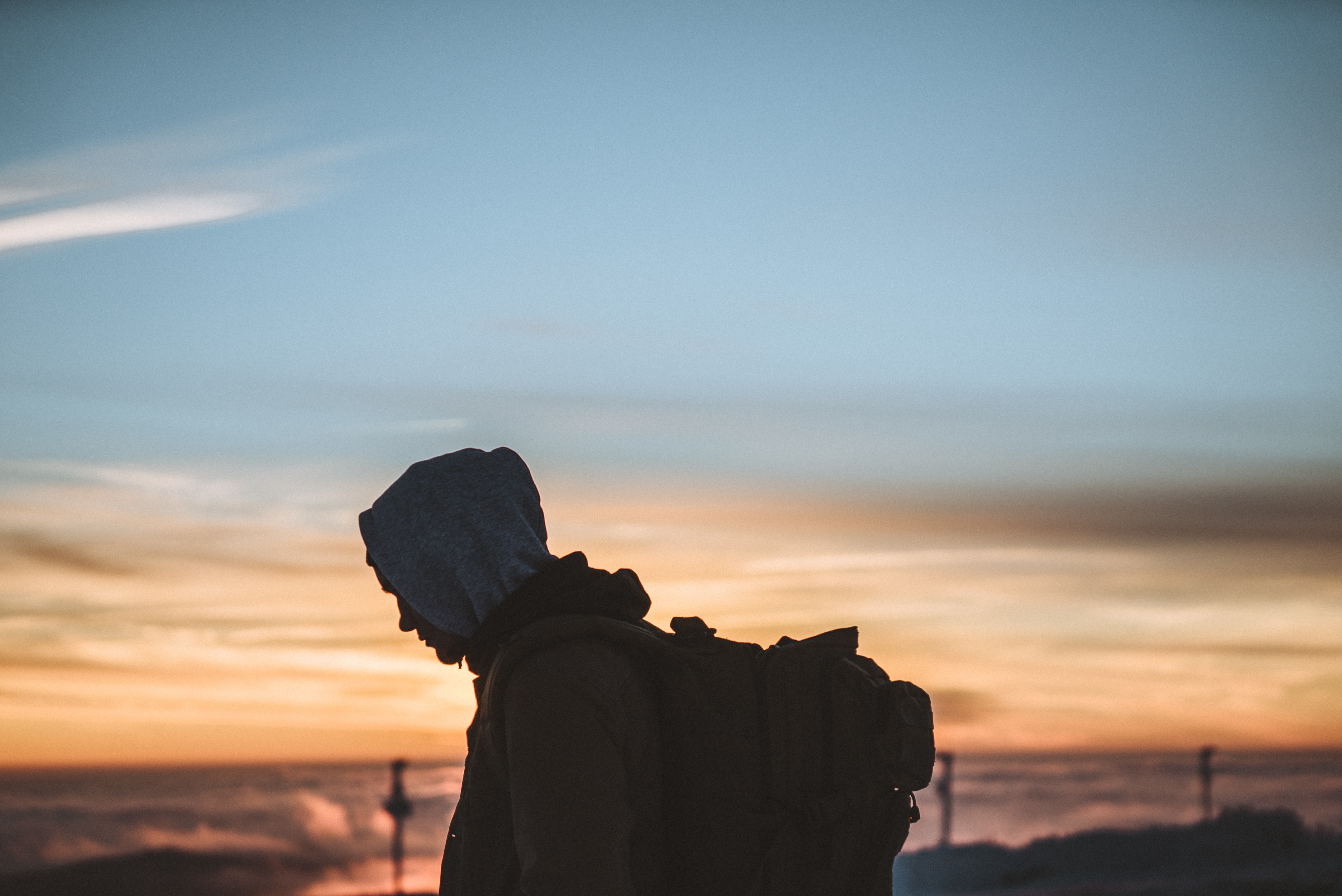 person walking with backpack at sunset  